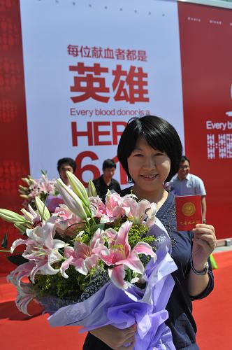 6月14日,獻(xiàn)血者王晶手持獻(xiàn)血證和醫(yī)務(wù)人員贈(zèng)送的鮮花留影。當(dāng)日是第9個(gè)世界獻(xiàn)血日,今年獻(xiàn)血日的主題是“每位獻(xiàn)血者都是英雄”。新華社發(fā)(劉長龍 攝)