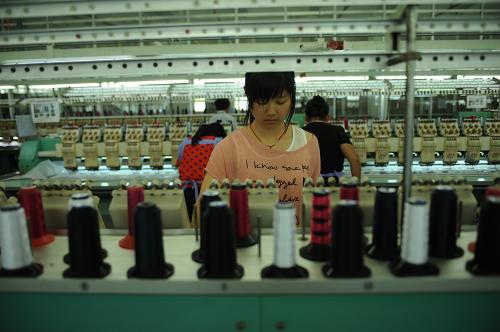 一名女工在對運(yùn)動鞋進(jìn)行電腦刺繡(攝于6月14日)。江西鄱陽縣裕泰鞋業(yè)是由臺商在江西投資建成的全江西省最大的制鞋基地。原本在廣東的工廠轉(zhuǎn)移到江西后,解決了當(dāng)?shù)貏趧恿蜆I(yè)。近年來由于勞動力成本上升、資源緊缺等因素,越來越多勞動力密集產(chǎn)業(yè)選擇由東部沿海地區(qū)向中西部轉(zhuǎn)移。新華社記者 周密 攝