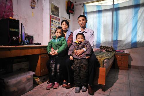 從廣州出發(fā)的前一天,高長(zhǎng)亮一家在租住的出租屋里合影。過(guò)了年,妻子和孩子們都要留在河南老家,一家四口就難得團(tuán)聚了(1月17日攝)。 今年31歲的高長(zhǎng)亮2008年從河南安陽(yáng)來(lái)到廣州打工,以開出租車為生。他和妻子高慶芳、6歲的女兒高子涵、4歲半的兒子高子豪一家四口租住在遠(yuǎn)離廣州市中心的“城中村”里,已經(jīng)四年沒(méi)回老家過(guò)年了。 女兒轉(zhuǎn)眼到了該上小學(xué)的年齡,高長(zhǎng)亮和妻子打算今年帶孩子回老家和親人過(guò)個(gè)團(tuán)圓年。為了節(jié)省開支,年后妻子高慶芳和兩個(gè)孩子就要留守老家了。高長(zhǎng)亮說(shuō):“不舍得也得舍啊……還是讓他們從小在家里邊吧 ,畢竟總要回家的??偛荒芤惠呑釉谕膺吢?#8230;…就想在這邊多賺點(diǎn)錢,在老家趕緊置套房?,F(xiàn)在的房?jī)r(jià)太貴,還得過(guò)幾年再說(shuō)。” 因?yàn)殄e(cuò)過(guò)了最佳購(gòu)票時(shí)間,又不熟悉新的訂票方式,在多次嘗試網(wǎng)絡(luò)訂票和電話訂票無(wú)果后,高長(zhǎng)亮和幾個(gè)老鄉(xiāng)還是把最后一線希望寄托在去售票點(diǎn)排隊(duì)上。轉(zhuǎn)了幾個(gè)售票點(diǎn),結(jié)果仍令他們失望:回安陽(yáng)的普通列車只剩站票了。于是,坐高鐵回家成了擺在他們面前的唯一選擇。高長(zhǎng)亮說(shuō):“剛開始舍不得啊,一張票710多元,以前我們坐臥鋪的話是377元,多了將近一倍。”不過(guò),眼看著歸期將近,
