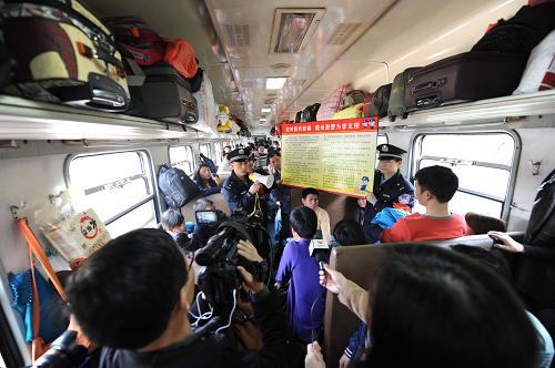 2月17日,在“愛(ài)心專列”上,鐵路部門工作人員向外出務(wù)工人員講解防扒防騙知識(shí)。新華社發(fā)(鮑贛生 攝)