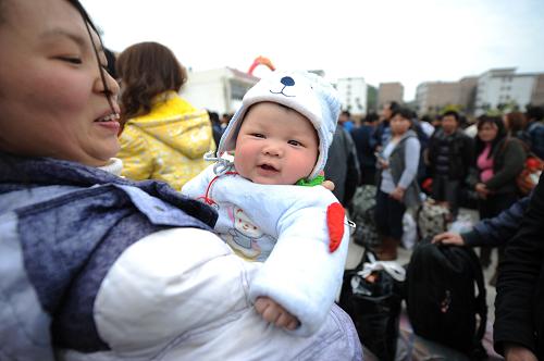 2月17日,一名不滿1歲的嬰兒隨家長(zhǎng)準(zhǔn)備乘坐“愛(ài)心專列”返城。新華社發(fā)(鮑贛生 攝)