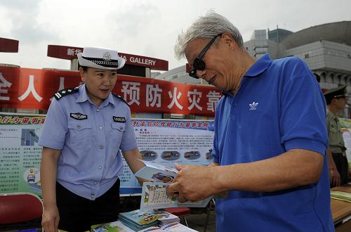 6月9日,在寧夏銀川市光明廣場,一名女警官在向市民發(fā)放安全宣傳材料。新華社發(fā)(李然 攝)