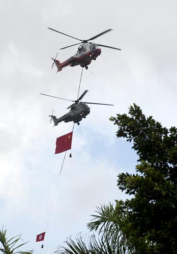 7月1日,懸掛國旗和香港特區(qū)區(qū)旗的直升飛機(jī)從金紫荊廣場上空飛過。 新華社記者 呂小煒 攝