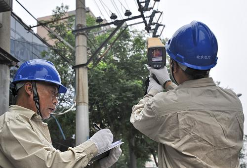 國家電網(wǎng)北京朝陽供電公司的技術(shù)人員在進行架空送電線路測溫(7月17日攝)。隨著夏季高溫天氣和汛期的到來,北京電網(wǎng)負荷逐步攀升,國家電網(wǎng)北京市電力公司實施架空線路綜合檢修、大型技術(shù)改造工程,提前預測電力負荷水平、加強電網(wǎng)監(jiān)控力度并加大對重點設(shè)備的巡視力度和對重載設(shè)備的測溫、測負荷等工作,結(jié)合惡劣天氣及時啟動應急響應,全力保障電力設(shè)備的安全穩(wěn)定運行。同時,技術(shù)人員使用測溫儀、紅外熱成像儀等設(shè)備,巡回對送電設(shè)備的接頭進行測溫,一旦發(fā)現(xiàn)隱患及時進行處理,保障應急處置效率,最大限度縮短故障處理的時間。新華社記者 李欣 攝