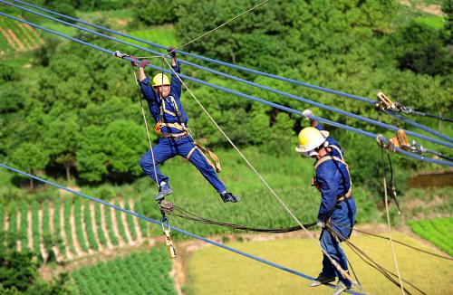 7月18日,在安徽省宣城市宣州區(qū)古泉鎮(zhèn)境內(nèi),電力工人冒著高溫在60多米高的輸電鐵塔上施工。當日,由國家電網(wǎng)安徽送變電工程公司承建的皖電東送1000千伏皖南變電站配套500千伏線路工程全線貫通。該條線路工程新建鐵塔115基,折合單回路全長約72千米,為安徽電網(wǎng)2013年一號工程。新華社發(fā)(鄭賢列 攝)
