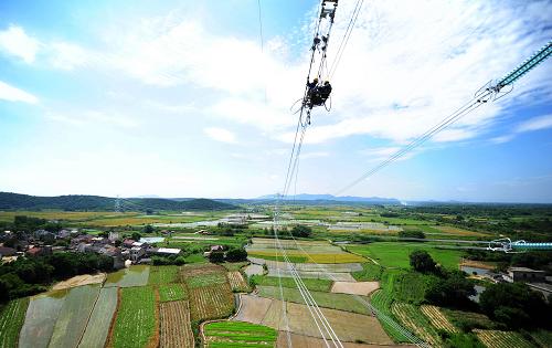 7月18日,在安徽省宣城市宣州區(qū)古泉鎮(zhèn)境內(nèi),電力工人冒著高溫在60多米高的輸電鐵塔上施工。新華社發(fā)(鄭賢列 攝)