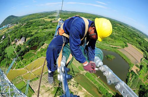 7月18日,在安徽省宣城市宣州區(qū)古泉鎮(zhèn)境內(nèi),電力工人冒著高溫在60多米高的輸電鐵塔上施工。新華社發(fā)(鄭賢列 攝)