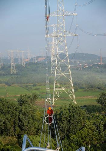 7月31日,在浙江長興縣林城鎮(zhèn)石英村,浙江省送變電工程公司工作人員冒著高溫在50多米高的“皖電東送”線路鐵塔進行最后的走線驗收。從8月1日開始,該線路將進入帶電測試階段。新華社記者 徐昱 攝