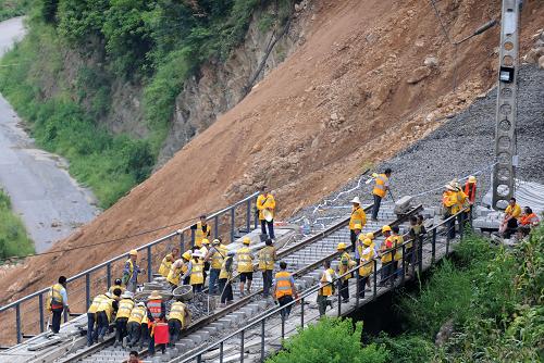 8月13日,成都鐵路局現(xiàn)場搶修人員在云南省大關(guān)縣天星鎮(zhèn)山體滑坡現(xiàn)場搶修被毀的鐵路。新華社記者 薛玉斌 攝
