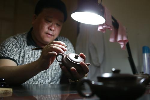 8月14日,在遼寧省西部的朝陽市喀左縣,從江蘇宜興北上創(chuàng)業(yè)的國家級工藝美術(shù)師劉曰明在工作室內(nèi)研究紫砂壺的工藝。新華社記者 任正來 攝
