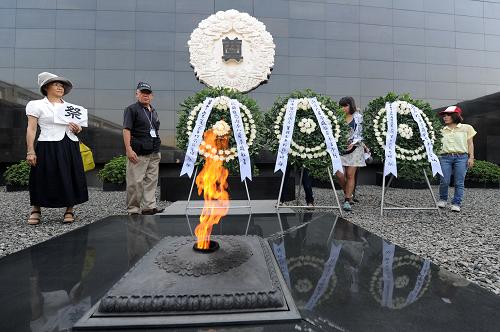 8月15日,參加和平集會的日本友人在侵華日軍南京大屠殺遇難同胞紀(jì)念館的祭場向南京大屠殺遇難者敬獻(xiàn)花圈。新華社記者 韓瑜慶 攝