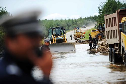 8月26日,在饒撫公路飛機場路口段,交警在指揮搶險車輛水中通行。新華社記者 王建威 攝
