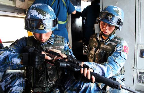 9月11日,在亞丁灣海域,中國海軍第十五批護(hù)航編隊(duì)特戰(zhàn)隊(duì)員在直升機(jī)上更換彈夾。新華社記者 梁舜 攝