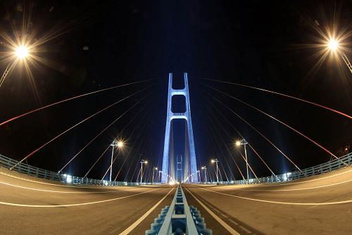 10月10日晚,江西九江長(zhǎng)江公路大橋的南北主塔景觀燈亮起。近日,即將通車的九江長(zhǎng)江公路大橋(九江長(zhǎng)江二橋)進(jìn)行調(diào)試景觀燈、荷載試驗(yàn)等通車前準(zhǔn)備工作。經(jīng)過(guò)四年建設(shè)的九江長(zhǎng)江公路大橋已進(jìn)入建設(shè)收尾階段,預(yù)計(jì)10月底竣工通車。該工程于2009年9月正式動(dòng)工建設(shè),起點(diǎn)位于江西省南九高速公路七里湖路段,終點(diǎn)接湖北省黃小高速公路小池收費(fèi)站北側(cè),是連接江西和湖北的重要通道,全長(zhǎng)25.19公里。九江長(zhǎng)江公路大橋建成通車后,對(duì)于緩解南北跨江交通壓力,推進(jìn)長(zhǎng)江中游城市集群建設(shè),將發(fā)揮關(guān)鍵作用。新華社發(fā)(張海巖 攝)