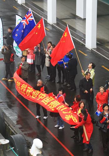 10月11日,新西蘭華人華僑揮舞五星紅旗在奧克蘭港碼頭迎接從祖國來的軍艦。新華社記者 查春明 攝