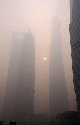 12月6日上午拍攝的籠罩在霧霾中的上海浦東陸家嘴三座標志性建筑——環(huán)球金融中心大廈、金茂大廈、正在建造的上海中心(自左至右)。新華社記者 任瓏 攝