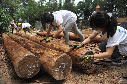 8月8日,參加山西新絳縣光馬村的白臺寺文化遺產(chǎn)修復(fù)保護(hù)工程的幾名志愿者在移動工程木料。新華社發(fā)(高新生 攝)