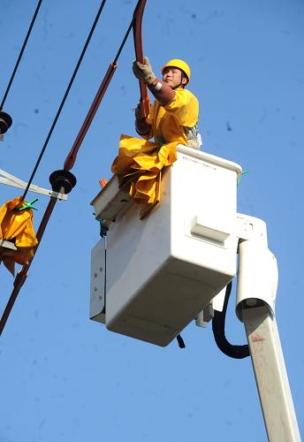 9月26日,國網(wǎng)河北廊坊供電公司作業(yè)人員在高空作業(yè)車上實施帶電接引,在不給其他用戶停電的情況下,為新增用戶“接火”供電。新華社記者 李曉果 攝
