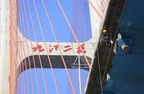 10月9日,工人對(duì)即將通車(chē)的九江長(zhǎng)江公路大橋橋面進(jìn)行后期涂裝。新華社發(fā)(張海巖 攝)