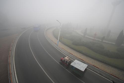 10月22日清晨,車(chē)輛行駛在霧霾籠罩的哈爾濱松花江公路大橋引橋上。新華社發(fā)(姚庭山 攝)