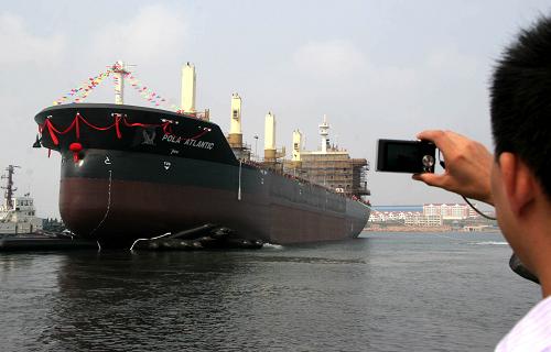 9月18日,觀眾在現場拍攝剛下水的“寶來·亞特蘭蒂克”號貨輪。當日,山東百步亭船業(yè)為英國船東建造的3.4萬載重噸散貨輪“寶來·亞特蘭蒂克”號在山東榮成下水。“寶來·亞特蘭蒂克”號貨輪總長180米,寬30米,載貨量3.4萬噸,是山東榮成承接制造的噸位最大的出口貨船。新華社發(fā)(于啟波 攝)