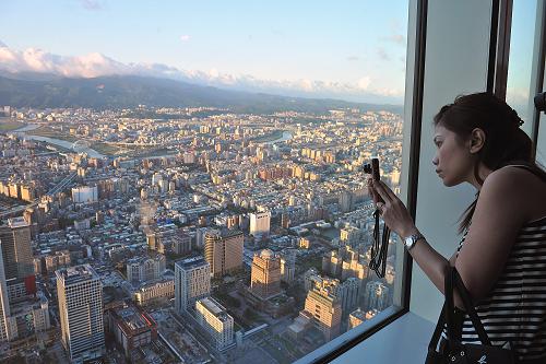 10月1日,來(lái)自廣東的一位游客在臺(tái)北101大廈觀景臺(tái)上拍攝臺(tái)北市貌。當(dāng)日是“十一”黃金周第一天,大陸來(lái)臺(tái)游客明顯增多,在臺(tái)北各景點(diǎn)和商城都可以看到不少大陸游客。據(jù)臺(tái)灣旅游部門預(yù)計(jì),黃金周期間約有2.6萬(wàn)名大陸游客來(lái)臺(tái)旅游,同比增加一倍。新華社記者 何俊昌 攝