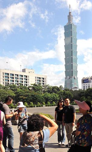 10月1日,大陸游客在臺(tái)北101大廈附近拍照留影。新華社記者 何俊昌 攝