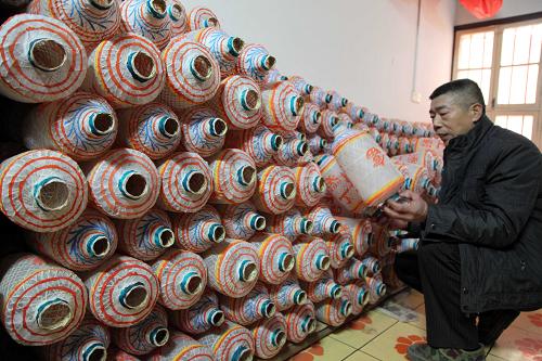 1月14日,在福建省莆田市東海鎮(zhèn)東沙村的油紙燈作坊里,手工藝人蔡起德在檢查油紙燈的質(zhì)量。新華社發(fā)(林劍冰 攝)