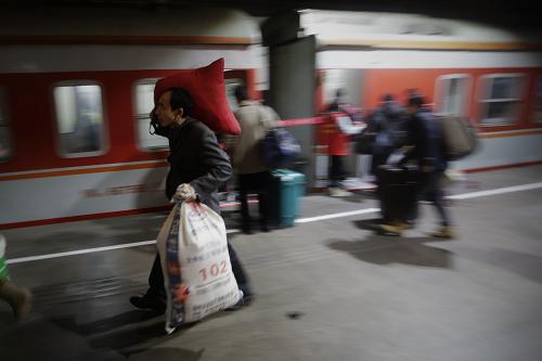 1月16日零時許,乘客背著行李在廣州火車站搭乘K9286次列車。當天凌晨0:49,從廣州火車站始發(fā)的春運首趟臨客列車——廣州至常德的K9286次列車,滿載著2647名旅客順利踏上歸家的旅途。2014年全國春運從1月16日開始,客流量預計將達36.2億人次。新華社記者 邢廣利 攝