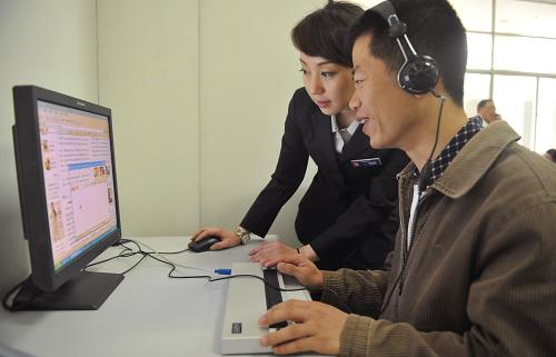 5月15日,工作人員(左)幫助盲人使用盲人專業(yè)電腦上網(wǎng)。新華社記者 歐東衢 攝