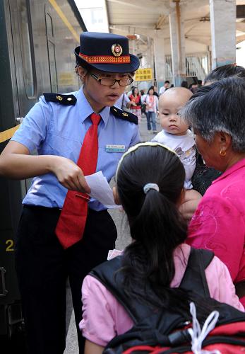 京藏車(chē)隊(duì)八組乘務(wù)員李瑾在T27次列車(chē)到達(dá)蘭州車(chē)站后為上車(chē)旅客服務(wù)(7月18日攝)。新華社記者 唐召明 攝