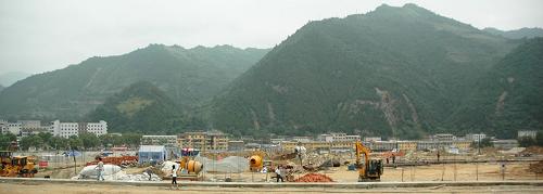 這是黃渚鎮(zhèn)建設(shè)中的王臺(tái)異地集中安置小區(qū)(8月8日攝)。這個(gè)小區(qū)全部為帶院落平房,集小區(qū)道路、供排水、綠化、文化活動(dòng)場(chǎng)所、市場(chǎng)等配套設(shè)施為一體。 2010年8月12日,甘肅省隴南市爆發(fā)“8.12”特大暴洪災(zāi)害,其核心災(zāi)區(qū)成縣黃渚鎮(zhèn)受災(zāi),整個(gè)鎮(zhèn)幾乎被暴雨從山上帶下來(lái)的樹木、石塊及淤泥掩埋。災(zāi)后,甘肅省及隴南市政府緊急安排災(zāi)后重建工作,對(duì)無(wú)生產(chǎn)資料、無(wú)房、無(wú)經(jīng)濟(jì)來(lái)源的重建戶每戶補(bǔ)貼7.5萬(wàn)元建新房。按選擇戶型的不同,這部分重建戶每戶自籌只需1萬(wàn)或2萬(wàn)3千元就可重新?lián)碛幸粋€(gè)新家。 在重建中,黃渚鎮(zhèn)實(shí)行“我的房子我重建”政策,充分發(fā)揮重建戶在重建中的主導(dǎo)作用,重建戶戶主為房屋重建的最大“監(jiān)理員”,房屋建設(shè)的每一步完工后,必須要房主滿意并簽字,工程隊(duì)才能進(jìn)行下一步的建筑施工。截止目前,黃渚鎮(zhèn)420戶重建戶的災(zāi)后重建工作全部開工,預(yù)計(jì)9月底完成主體工程,11月底前全部入住新居,溫暖過(guò)冬。 新華社記者姜偉超攝