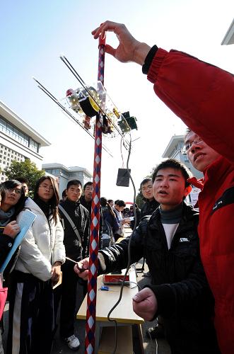 12月22日,兩名學生在演示其設計的爬桿機器人。這種爬桿機器人可用于吊橋鋼索探傷、遠距離取樣等高空、艱險作業(yè)。新華社記者 孫參 攝