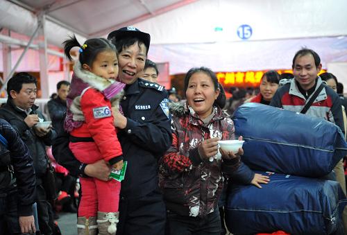1月16日,一名警察抱著一位旅客的小孩前往休息區(qū)。新華社發(fā)(徐昕 攝)