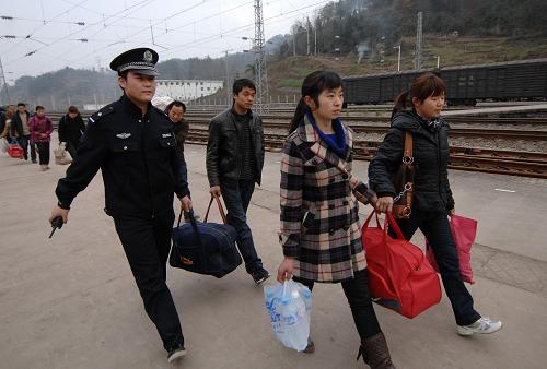1月31日,鐵警在宣漢車(chē)站幫旅客提行李進(jìn)站乘車(chē)。 當(dāng)日是正月初九,由四川宣漢始發(fā)的L136次農(nóng)民工專(zhuān)列載著2000余名乘客開(kāi)往廣州,西安鐵路公安局安康公安處組織大量警力在始發(fā)站投入安全保衛(wèi)工作,并為外出務(wù)工人員宣講安全乘車(chē)、防盜防騙知識(shí)。 新華社記者 李一博 攝