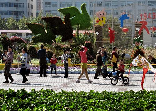 10月3日,市民在鄭州一個休閑廣場的大型立體花壇前賞景、游覽。 國慶長假期間,在河南省鄭州市的休閑廣場、街心花園和道路兩旁,由500萬盆各色鮮花組成的花壇、花廊、花圃,猶如一幅幅優(yōu)美、和諧的立體風景畫,扮靚了節(jié)日的鄭州。 新華社記者王頌攝