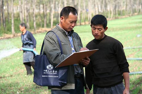 10月23日,宋兆行(左)在田間對村民進(jìn)行人口普查前的摸底登記。 今年48歲的宋兆行是山東省臨沂市郯城縣郯城鎮(zhèn)后趙村的一名人口普查員。他所在的村有317戶、1123人。由于正是農(nóng)忙時(shí)節(jié),他每天早上從6點(diǎn)多開始便要奔波于農(nóng)戶家中和田間地頭,做好正式入戶登記前的摸底工作,一天要走30多里路。據(jù)了解,目前郯城縣共有5000余名人口普查員奮戰(zhàn)在人口普查工作一線。 新華社發(fā)(張春雷 攝)