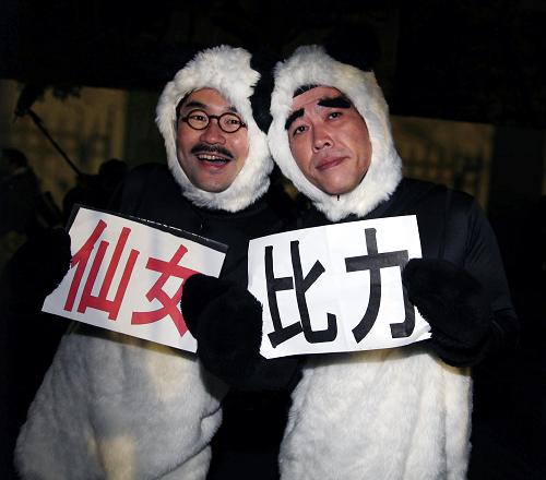 2月21日,在日本東京的上野動(dòng)物園門口,兩名男子身著“熊貓”服裝舉著“比力”和“仙女”的名字等候中國(guó)大熊貓到來。 當(dāng)日,來自中國(guó)四川的大熊貓“比力”和“仙女”抵達(dá)日本東京成田機(jī)場(chǎng),當(dāng)天深夜入住東京上野動(dòng)物園。這是2008年4月大熊貓“陵陵”因衰老離世以來,大熊貓?jiān)僖淮维F(xiàn)身東京。 新華社記者馮武勇攝
