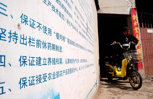 河南省沁陽(yáng)一家養(yǎng)豬場(chǎng)大門(mén)口張?zhí)嘘P(guān)養(yǎng)殖規(guī)則(3月17日攝)。 “瘦肉精”豬肉遭到媒體曝光后,河南省政府發(fā)布緊急通告,重申嚴(yán)禁在飼料及動(dòng)物飲用水中添加“瘦肉精”等違禁品,并派出多支調(diào)查組到河南各地開(kāi)展全面排查。 新華社記者 朱祥 攝