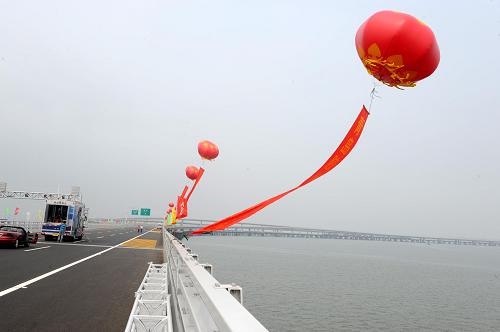 6月30日,汽車行駛在青島膠州灣大橋上。 當(dāng)日,青島膠州灣大橋正式通車,這是我國北方冰凍海域首座特大型橋梁集群工程,是國道主干線青島至蘭州高速公路的起點(diǎn)段,大橋全長36.48公里,是目前世界上已建成的最長的跨海大橋。大橋起于青島市東部高科園,跨越膠州灣,在黃島側(cè)與已建成的濟(jì)青南線順接,使青島、黃島和紅島實(shí)現(xiàn)“品”字形連接。大橋?yàn)殡p向六車道高速公路兼城市快速路八車道,設(shè)計(jì)行車速度80公里每小時(shí),橋梁寬度35米,設(shè)計(jì)基準(zhǔn)期100年。 新華社記者 范長國 攝