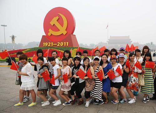 7月1日,一隊游客在廣場“紅心向黨”花壇前合影。 當日,來自全國各地的數(shù)萬名群眾匯聚北京天安門廣場,觀看隆重的升旗儀式,紀念中國共產(chǎn)黨成立90周年。 新華社發(fā)(李方宇 攝)