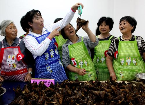 6月18日,工作人員在浙江寧波北侖區(qū)陳山社區(qū)老年人包粽子比賽現(xiàn)場(chǎng)稱粽子重量。當(dāng)日,浙江寧波北侖小港陳山社區(qū)舉行社區(qū)老人迎端午包粽子比賽。社區(qū)老人兩人一組,進(jìn)行蒙眼睛包粽子、包“默契粽”、包“迷你粽”、包“長(zhǎng)鼻粽”、包“連心粽”等比賽,熱熱鬧鬧迎接端午節(jié)的到來(lái)。新華社發(fā)(索向魯 攝)