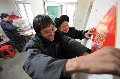 2月6日,留守農(nóng)民工李多華(中)和孤寡老人阮懷傳(右)一起貼春聯(lián)。臨近新春,安徽省蜀山經(jīng)濟(jì)開發(fā)區(qū)衛(wèi)星社區(qū)組織轄區(qū)工地不回家的農(nóng)民工和社區(qū)內(nèi)的孤寡老人們結(jié)對(duì)子,不回家的農(nóng)民工和老人們一起貼春聯(lián)、包餃子、選年貨,熱熱鬧鬧過(guò)大年。據(jù)介紹,蜀山經(jīng)濟(jì)開發(fā)區(qū)衛(wèi)星社區(qū)共促成了十組這樣的臨時(shí)家庭。新華社記者 郭晨 攝