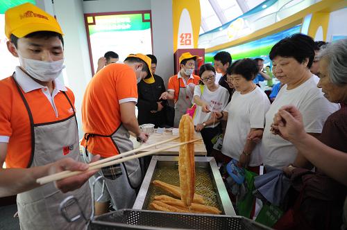 6月14日,市民在參觀和品嘗展出的無(wú)鋁“放心油條”。 當(dāng)日,2013年浙江省食品安全知識(shí)展覽在杭州浙江省科技館開(kāi)幕。本次展覽以“誠(chéng)信做食品,理性看安全”為主題,設(shè)有食品安全監(jiān)管部門展區(qū)、企業(yè)展區(qū)等。為讓普通市民能夠了解到與食品安全相關(guān)的知識(shí),普及食品安全觀念,展覽還專門設(shè)立互動(dòng)活動(dòng),由專業(yè)人士為參觀者答疑解惑。 新華社記者 鞠煥宗 攝