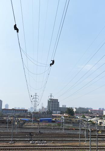 7月22日,國家電網(wǎng)河北秦皇島供電公司的電力工人在為110千伏李(莊)鐵(莊)線更換導(dǎo)線。 近日,秦皇島供電公司對跨越鐵路京哈線(北京-哈爾濱)、大秦線(大同-秦皇島)的110千伏李(李莊)鐵(鐵莊)線進(jìn)行電力線路改造施工。據(jù)了解,該段改造線路采取了由鐵塔單懸垂絕緣子串改為雙懸垂絕緣子串的技術(shù)措施,僅用時1小時40分鐘,就完成了560米架空導(dǎo)線的更換工作,為鐵路大動脈安全行車提供了保障。 新華社發(fā)(王勝利 攝)