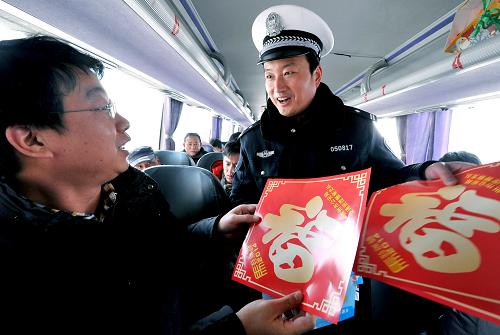 1月16日,交警在安徽滁州客運(yùn)總站向乘客贈(zèng)送印有安全提示的“福”字。 當(dāng)日,2014年春運(yùn)正式開始。 新華社發(fā)(王家國 攝)