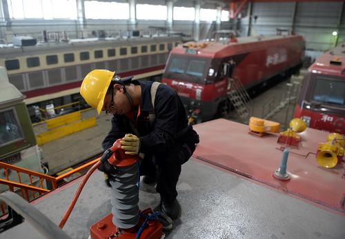 我國首批新型火車頭投入春運 1月24日,蘭州鐵路局蘭西機務(wù)段工人對和諧3D型機車進行上線前的最后檢查。 今年春運期間,由中國北車集團大連機車車輛有限公司研制的首批和諧3D型客運電力機車正式投入運營。這個型號的機車最高時速160公里,牽引載客量是動車組的6倍,可以牽引20節(jié)旅客列車,一次最多可輸送3000名旅客,在沒有開通高鐵的地方也能讓旅客實現(xiàn)快捷出行。據(jù)了解,大連機輛公司已向鐵路提供了首批40臺和諧3D型客運電力機車,配屬沈陽、西安、武漢和蘭州鐵路局,并在春運期間全部上線。 新華社記者 聶建江 攝