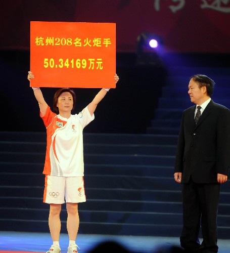 5月18日,在奧運圣火杭州站傳遞的終點――黃龍體育館,最后一棒火炬手吳小璇將杭州站所有火炬手的捐款捐獻給四川地震災區(qū)。當日,北京奧運會圣火在浙江杭州傳遞。 新華社記者徐昱攝