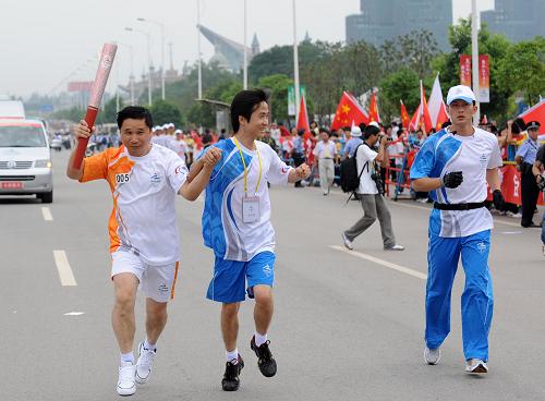 8月31日,火炬手祝剛(左)手持火炬?zhèn)鬟f。當(dāng)日,北京殘奧會圣火在長沙進行傳遞。新華社記者金良快 攝