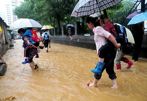 6月14日,湖北黃石月亮山小學(xué)的老師背著學(xué)生淌水回家。 新華社發(fā)(邱孝威 攝)